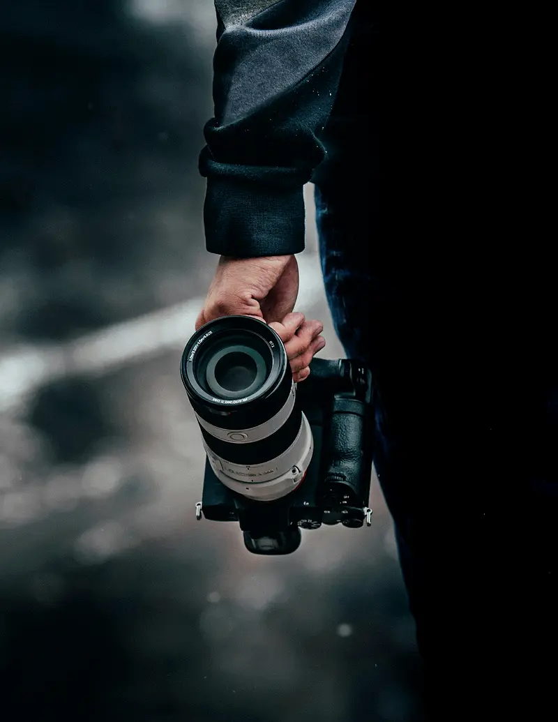 Appareil photo équipé d’un téléobjectif tenu à la main
